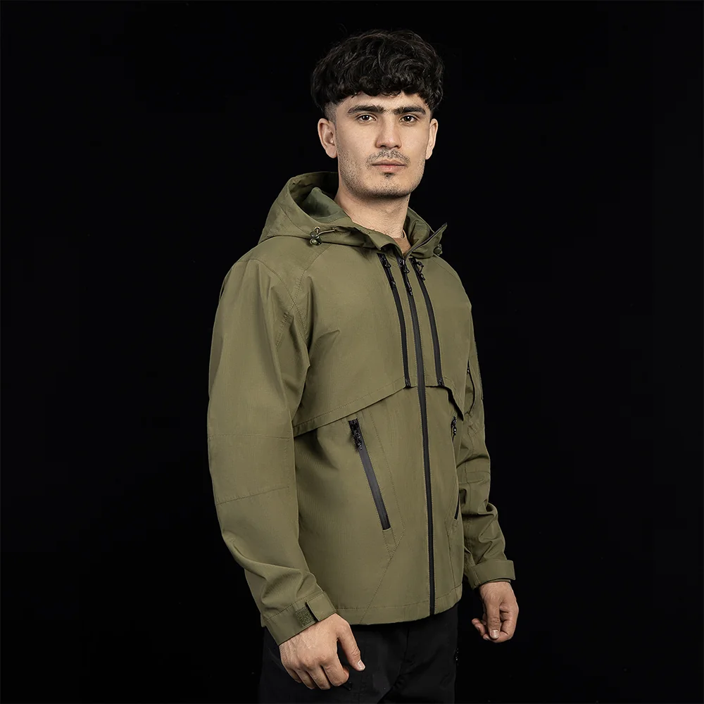 Men’s jacket windbreaker in olive with hood. Comfortable and versatile hard shell jacket for hiking, travel, and outdoor activities.