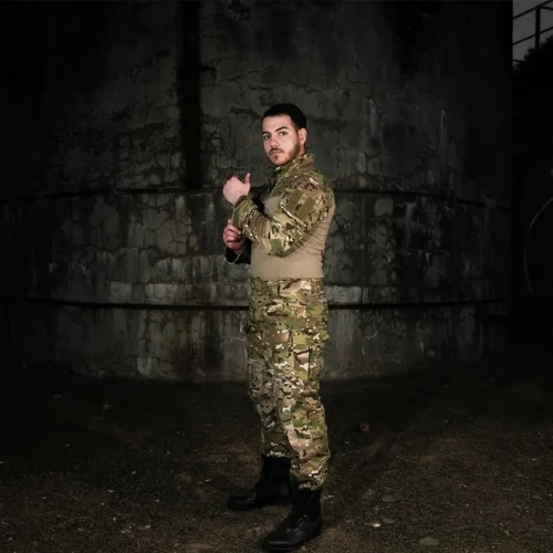 Model wearing camo uniform three-piece tactical suit, ideal for military training, outdoor survival, and airsoft combat scenarios.
