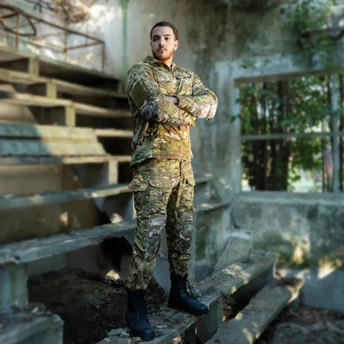 Multicam Tactical Suit – Combat Uniform with Knee Pads Model wearing multicam tactical suit, featuring breathable fabric, reinforced knees and multiple pockets for military and outdoor use.