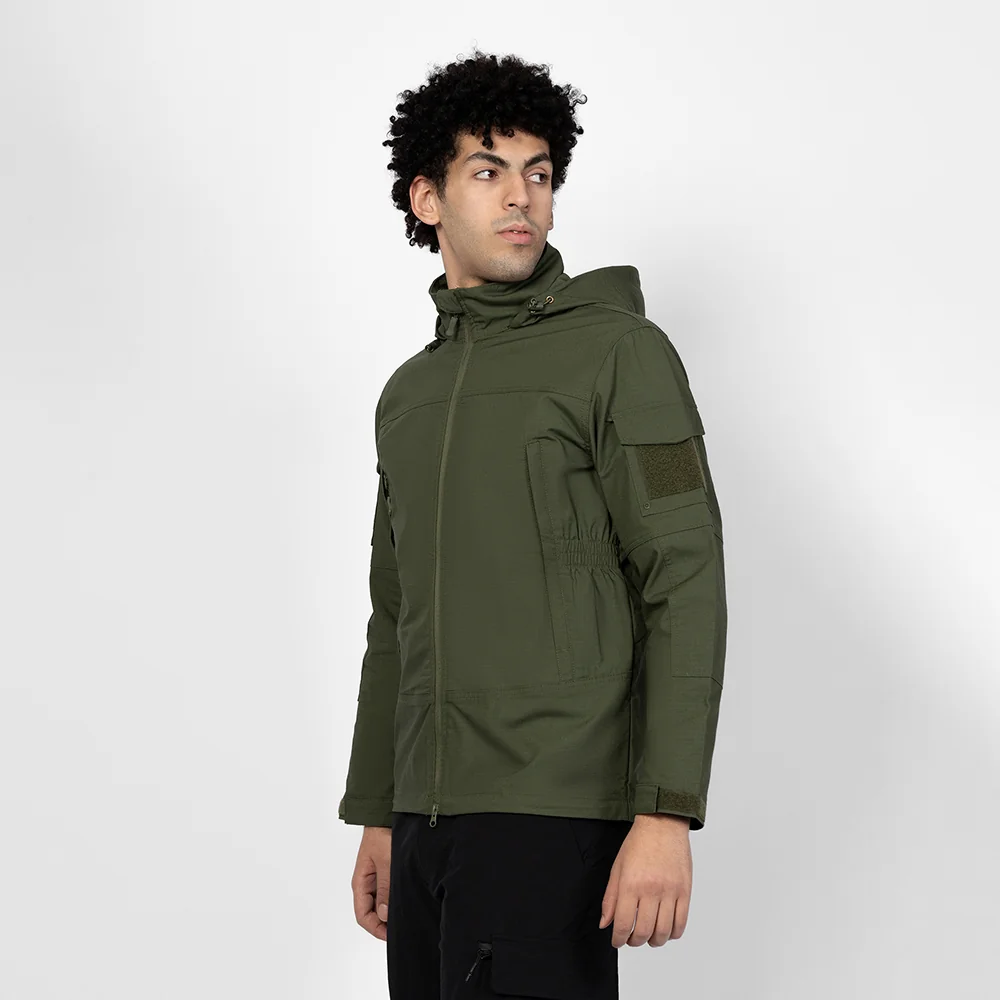 Model wearing army green softshell jacket. Breathable and waterproof design with hood, ideal for hiking, camping, and tactical outdoor missions.