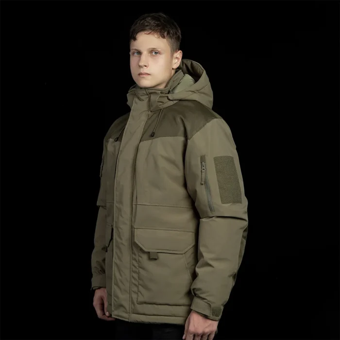 Men’s army green winter tactical coat with protective hood and functional arm pockets. Ideal for outdoor missions and cold climates.