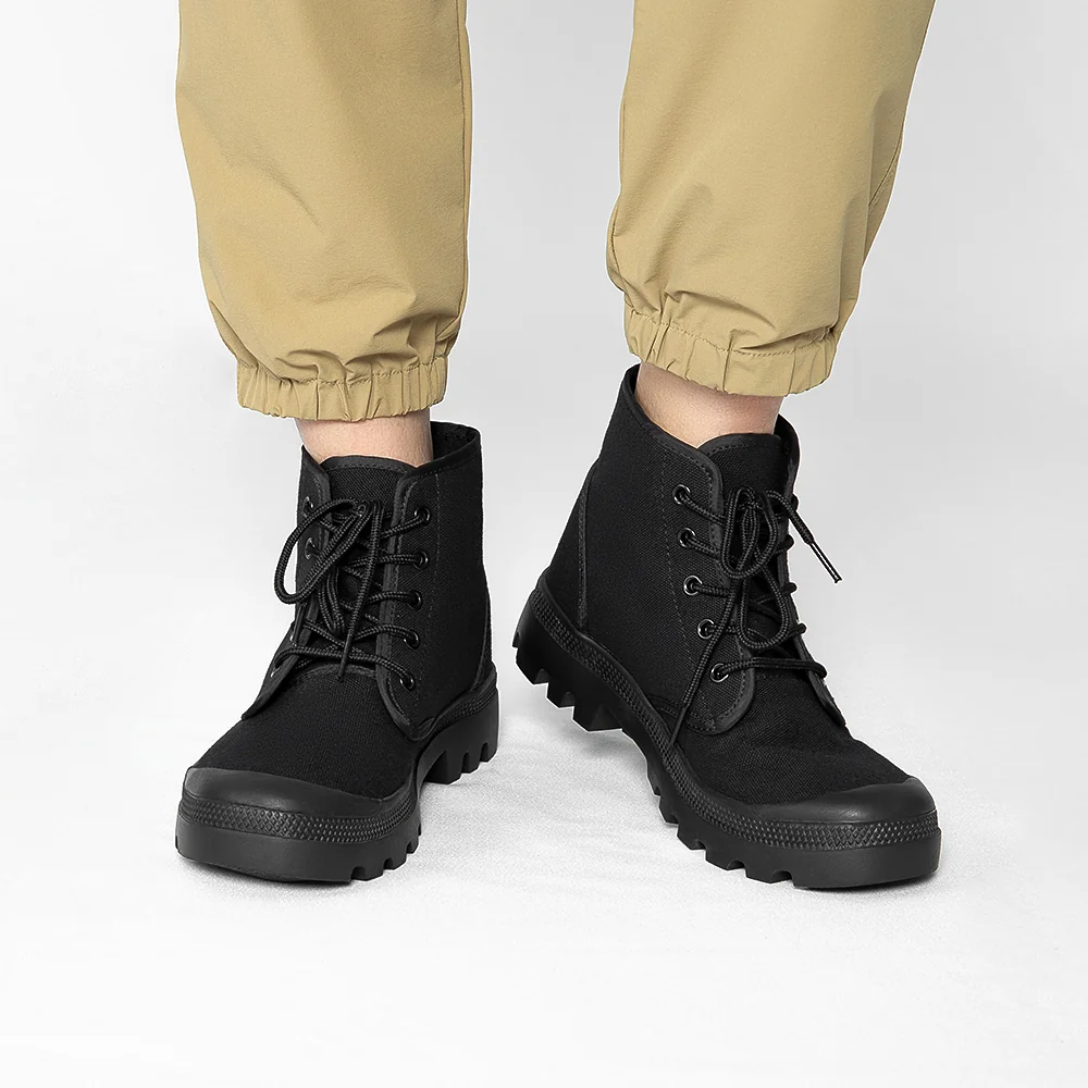 Model wearing men’s black combat boots with rugged sole and lace-up front, perfect for tactical missions and daily outdoor wear.
