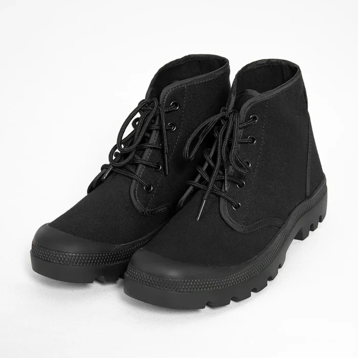 Pair of men’s black combat boots with textured rubber outsole and reinforced toe for durability and protection on rough terrain.
