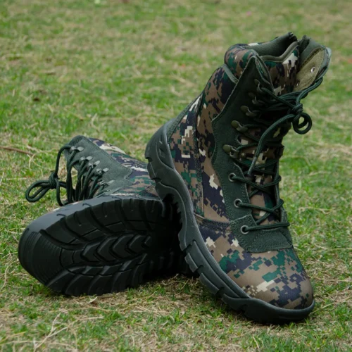 Camouflage army combat boots placed on grass, highlighting anti-slip sole, durable fabric, and rugged military performance design.