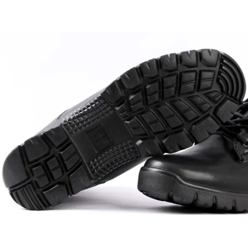 Close-up of black combat boots outsole featuring deep tread pattern and high-grip rubber design for stability and slip resistance.