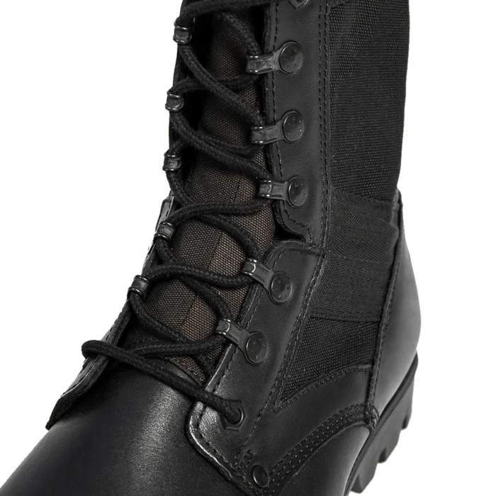 Detailed close-up of black leather military boots showing reinforced eyelets, tight stitching, and durable fabric-lace integration.