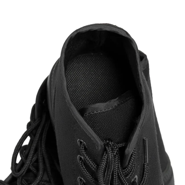 Close-up view of men’s black combat boots showing sturdy laces, durable stitching, and breathable fabric upper.