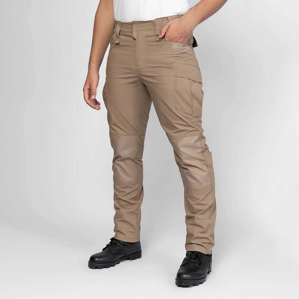 Khaki tactical work pants shown on model from an angled view, highlighting ergonomic cut, articulated knees, and functional cargo pockets for long-hour work environments.