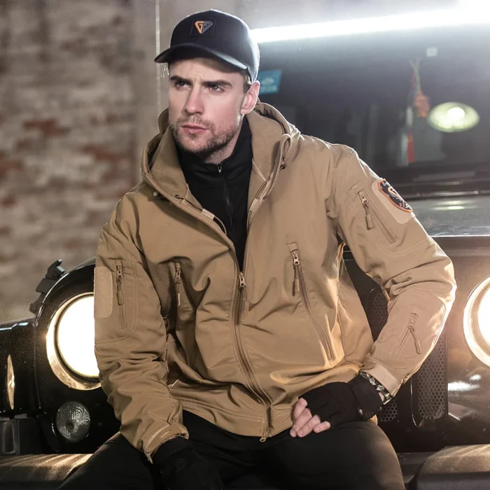 Khaki tactical softshell jacket worn by model, featuring windproof softshell fabric, multiple zipper pockets and adjustable cuffs, ideal for security teams, patrol duty and outdoor operations.