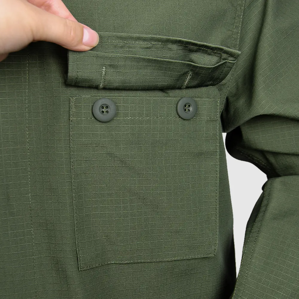 Close-up of chest pocket and button closure on a BDU-style jacket. Review stitching methods, pocket sizing, and reinforcement options for long-wear uniform programs.