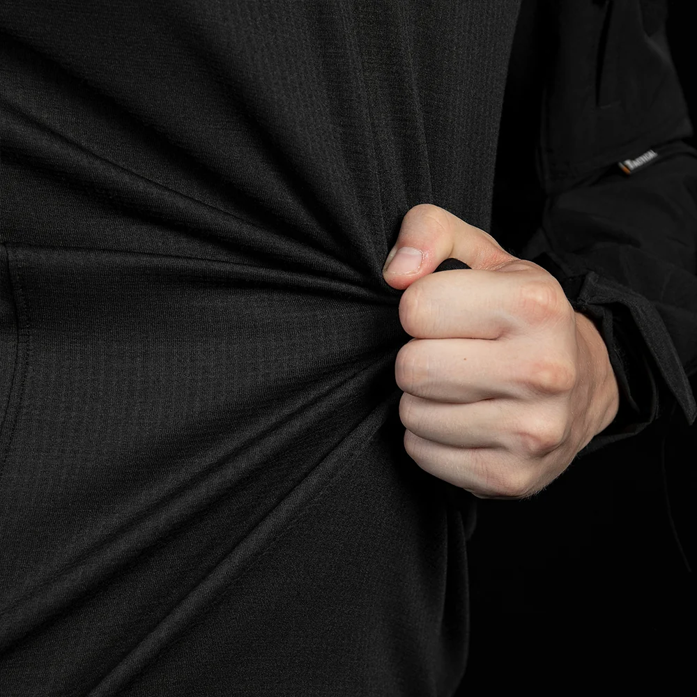 Close-up of black tactical training shirt knit fabric showing stretch recovery and comfort for movement. Suitable for OEM/ODM combat shirt programs with performance fabric selection and durability requirements.